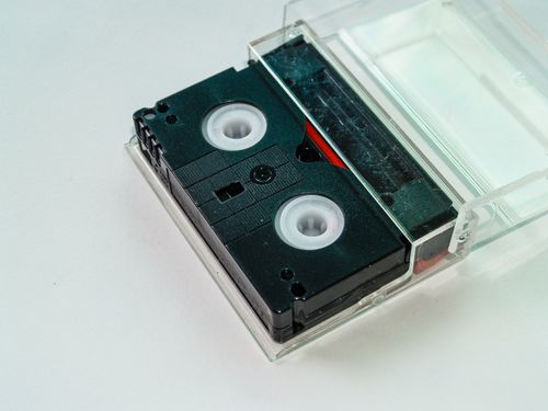 Free Close-up of a retro black cassette tape placed in a transparent plastic case, ideal for nostalgia-themed projects. Stock Photo
