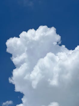 Bright cumulus clouds in clear blue sky, perfect for wallpapers.