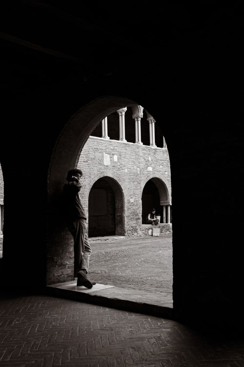 Free Artistic black and white photograph of a man in an archway, capturing architectural elegance. Stock Photo