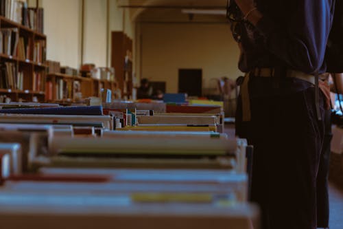 Closeup of a Person Standing by a Books Catalog in a Library