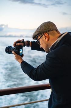 A man taking a photo of the sea in İstanbul, showcasing travel and lifestyle photography.