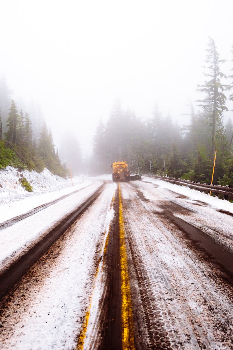 Yellow Tractor Clearing Snow On Road