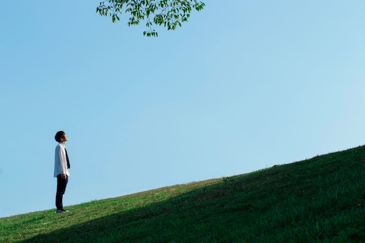 Man In Shirt Standing And Looking Up On Hill