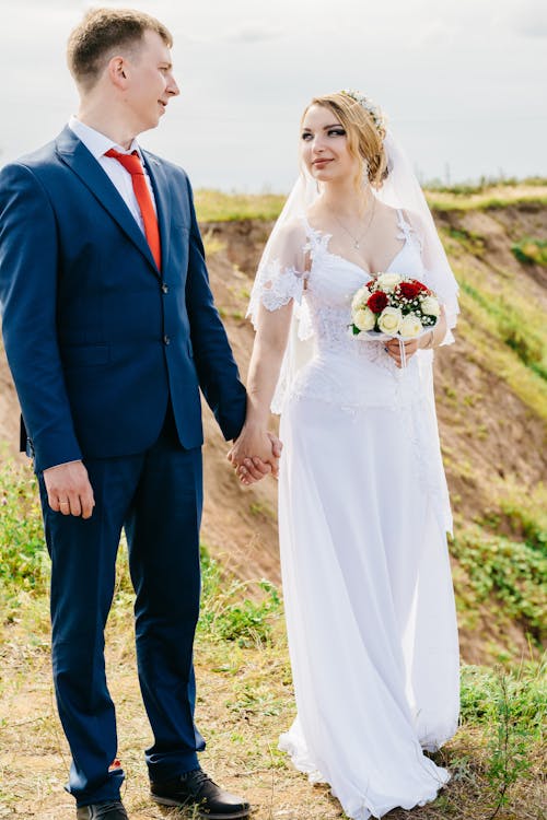 Two Man and Woman Staring and Holding Hands at Each Other While Standing on Cliff