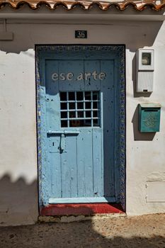 Rustic blue door in Altea, Spain, adorned with artful details and a vintage mailbox.