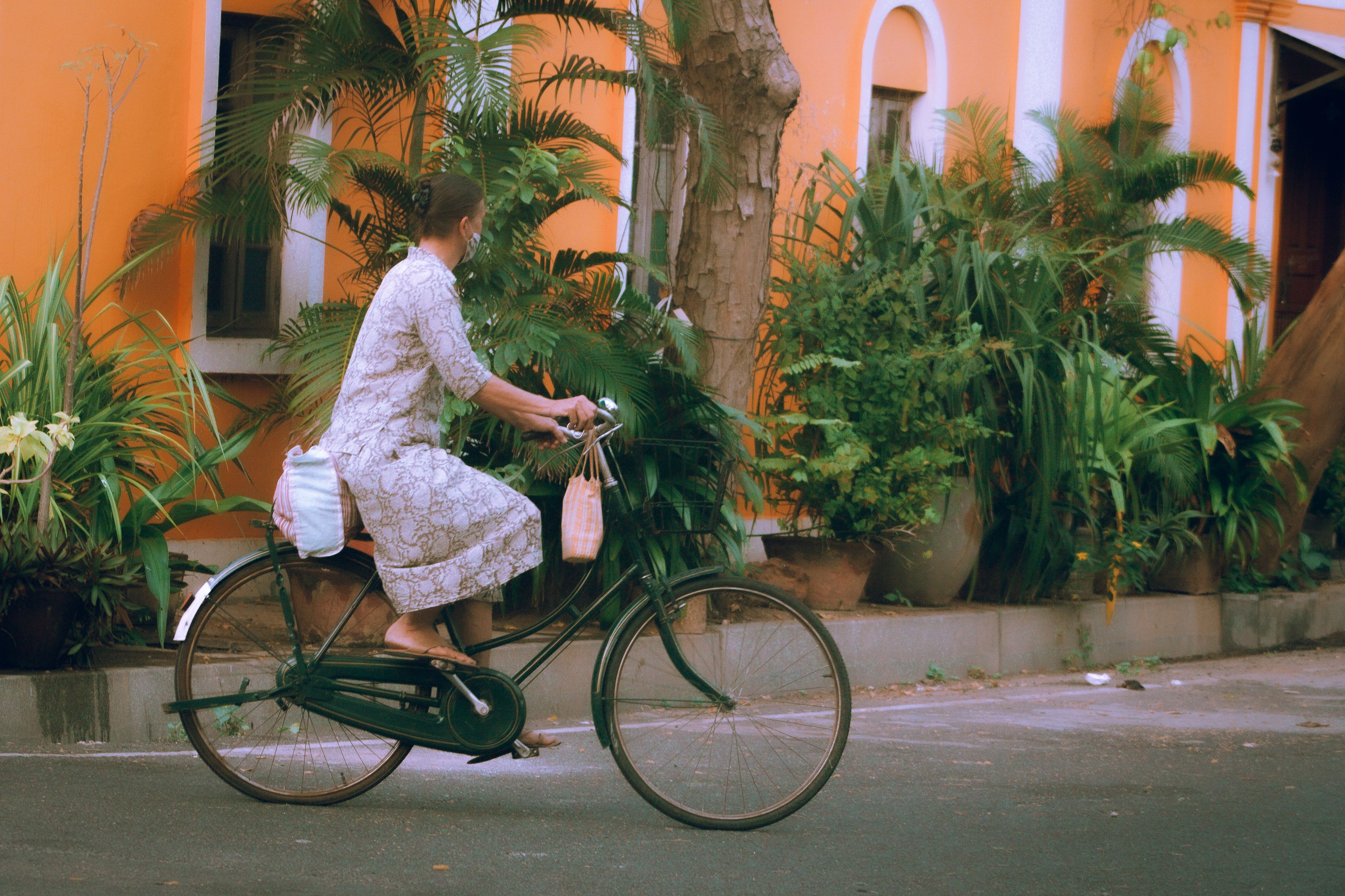 Woman in Floral Dress Riding a Black Bicycle · Free Stock Photo