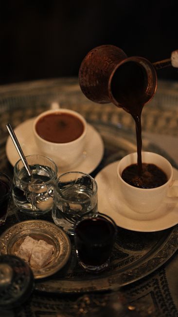 Traditional Turkish coffee being poured in Safranbolu with detailed utensils and cups.