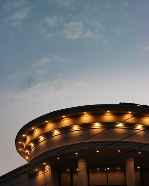 A beautifully illuminated building exterior with columns against a twilight sky.