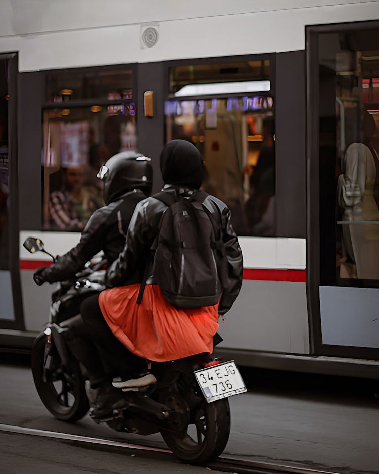 People Wearing Helmet Riding On A Motorcycle Beside The Bus