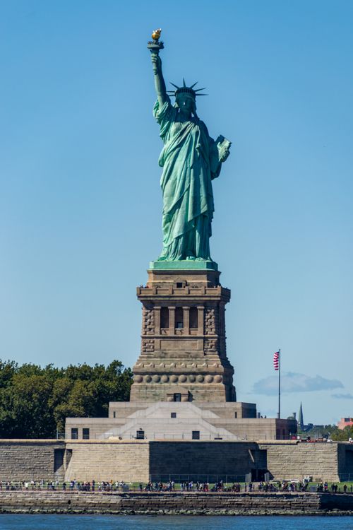 Free Iconic Statue of Liberty under clear blue sky in New York City, popular for tourism. Stock Photo