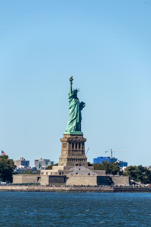 Free The iconic Statue of Liberty stands majestically against a clear blue sky in New York. Stock Photo