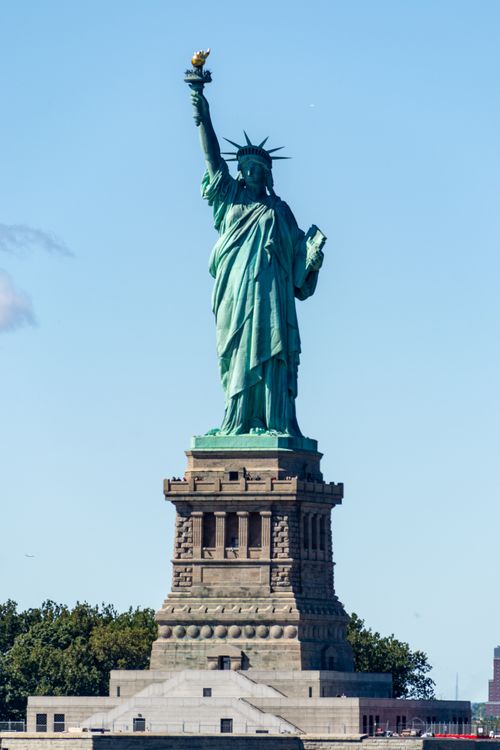 Free The Statue of Liberty against a clear blue sky, a symbol of freedom in New York City. Stock Photo