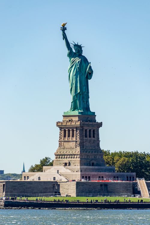 Free Majestic Statue of Liberty standing tall on a sunny day in New York City. Stock Photo