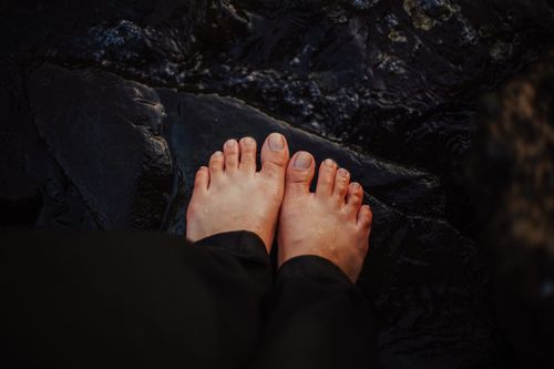 Free Close-up of feet on wet rocks, embracing natural textures and a connection to earth. Stock Photo
