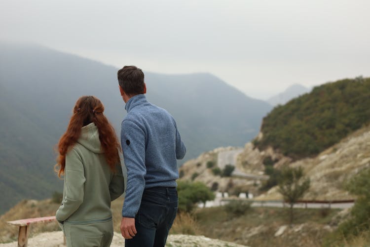 Pair Of Tourists Looking At A Valley