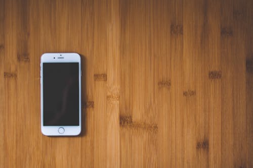 Silver Iphone 6 on Brown Wooden Surface