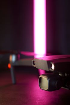 Close-up of a drone illuminated by pink LED light, highlighting technology and innovation.