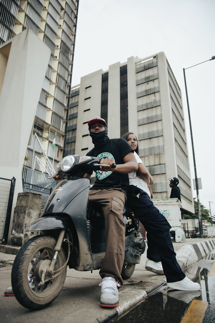 Young Man And Woman On A Scooter In City 