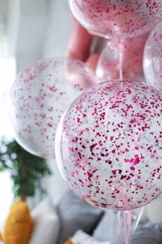 Bright and festive pink confetti balloons photographed indoors, ideal for celebration themes.