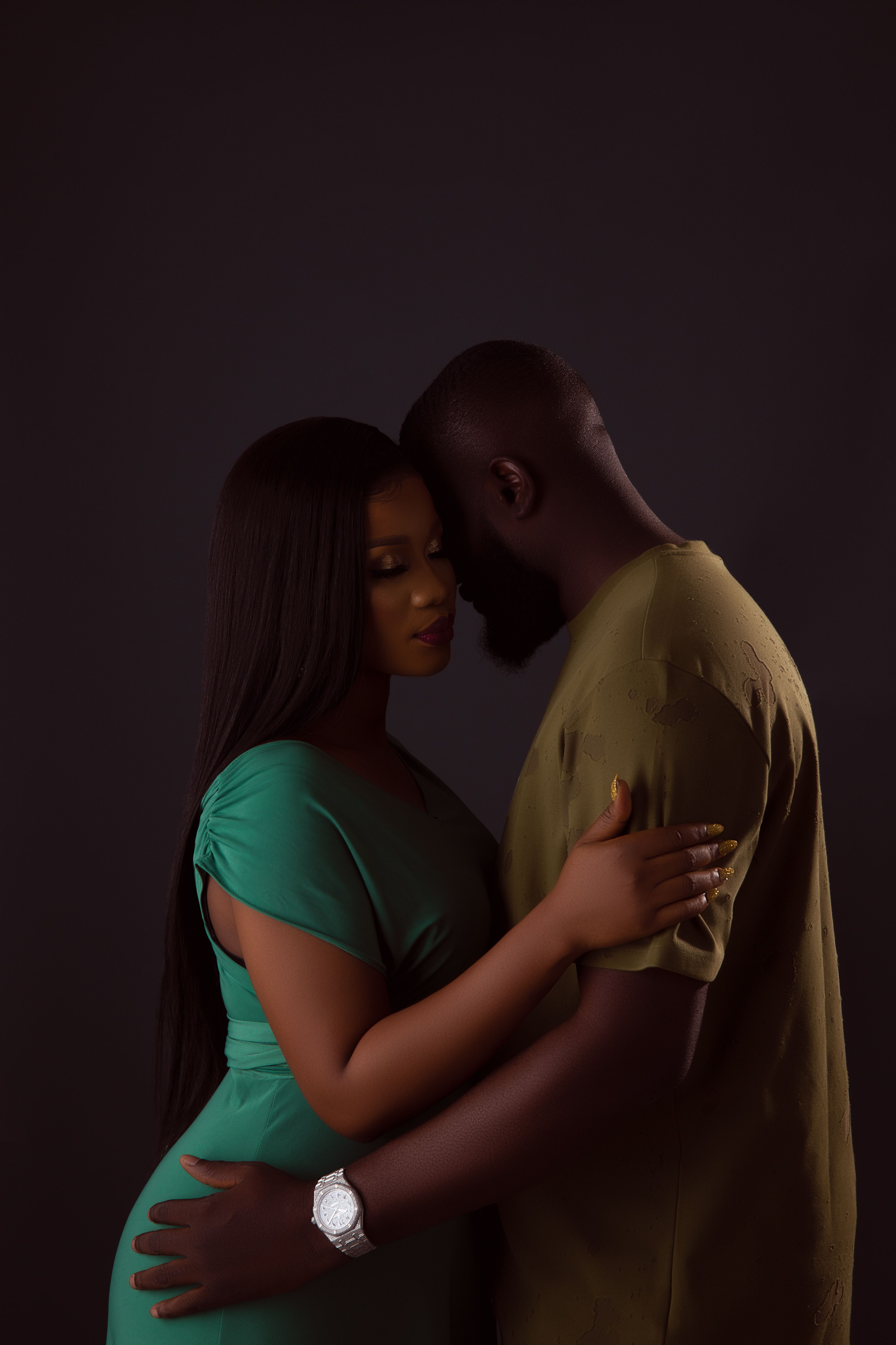 A couple in a warm embrace in a studio, conveying a sense of love and affection.