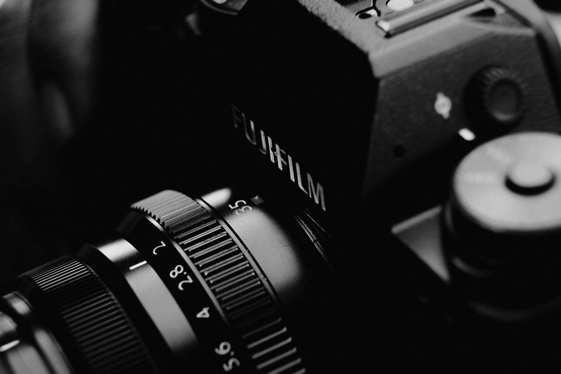 Monochrome close-up shot of a camera lens showcasing details and craftsmanship.