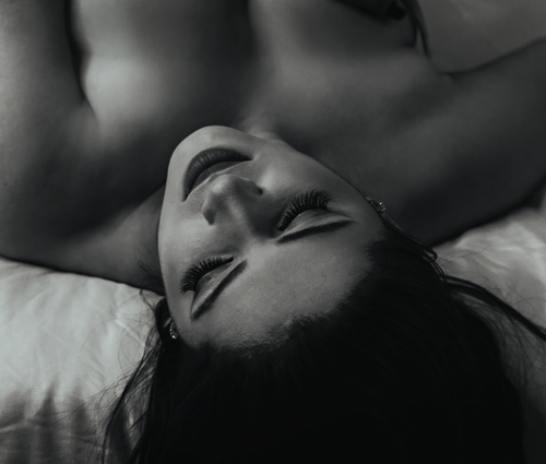 Free Elegant black and white portrait of a woman lying down, evoking tranquility. Stock Photo