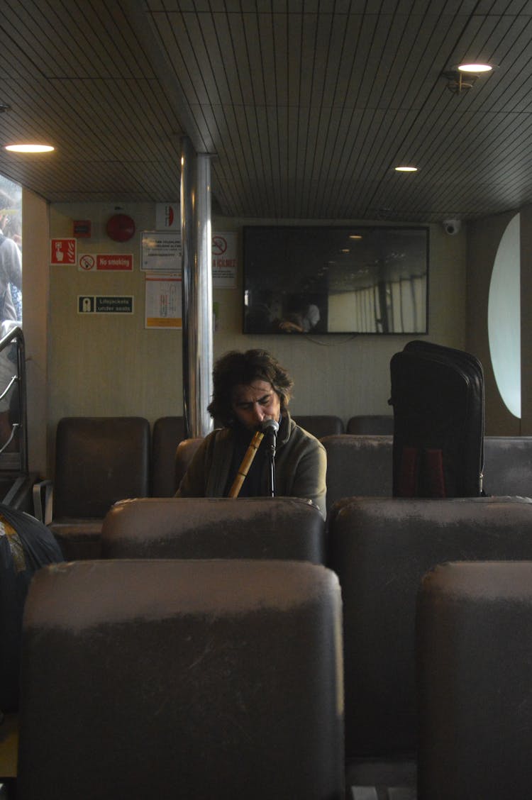 Man Traveling On A Ferry And Playing A Flute