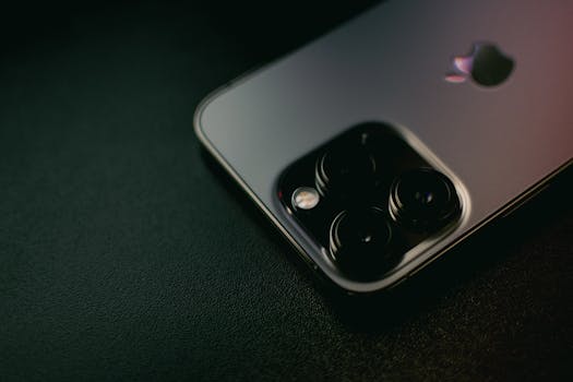 Detailed view of a smartphone with multiple camera lenses on a dark surface.