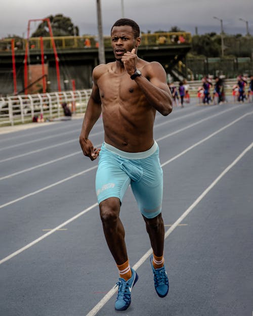 Shirtless Man Running on the Track