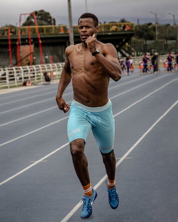 Shirtless Man Running On The Track