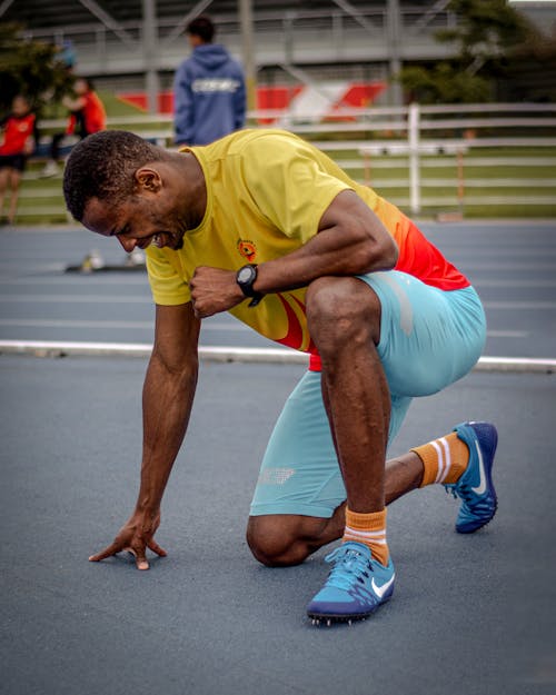 Photo of a Sportsman Kneeling on a Track