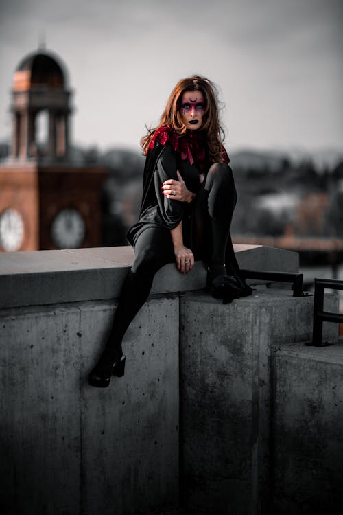 A Woman with Makeup Sitting in a City 