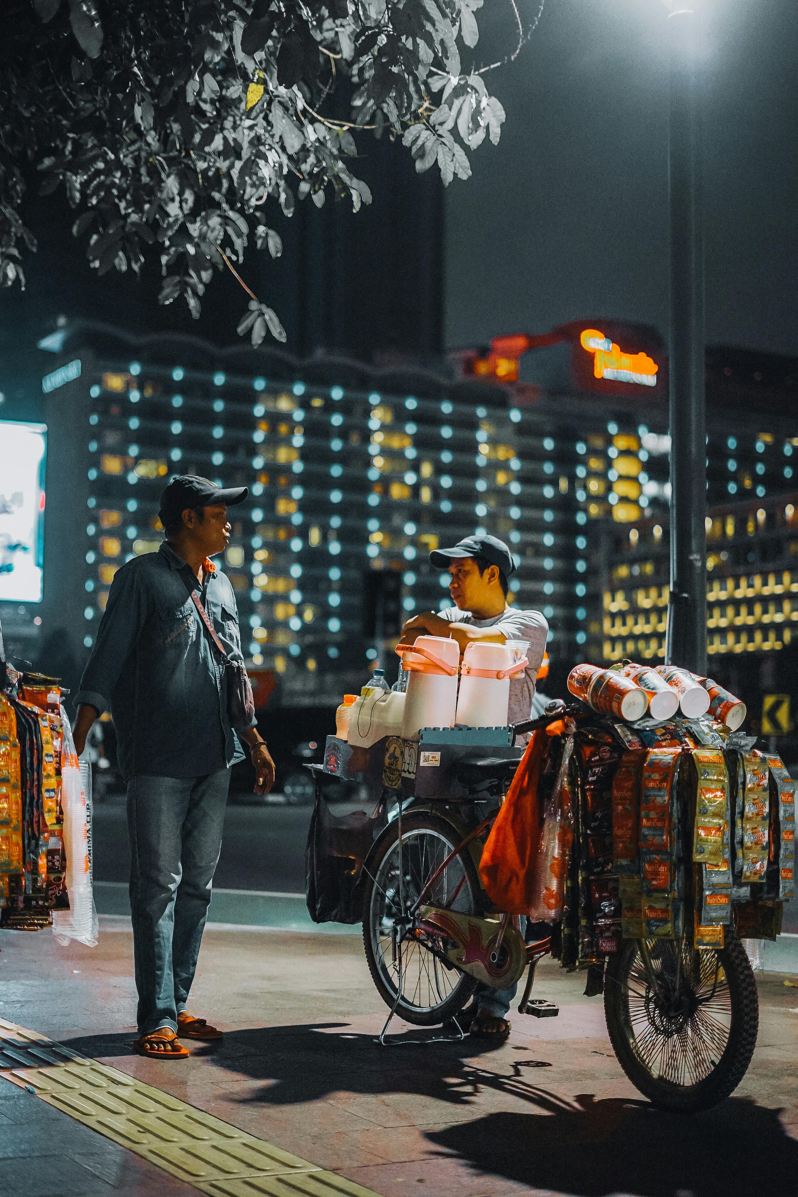 man selling on the bicycle in the sidewalk