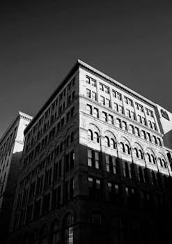 黑白照片中的城市建筑，突出了戏剧性的阴影和几何线条