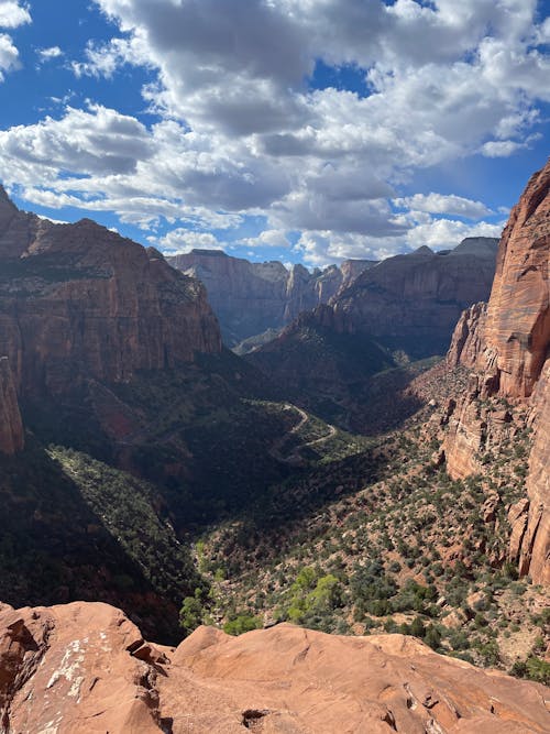 Free Explore the breathtaking landscape of a majestic canyon beneath a blue sky filled with clouds. Stock Photo