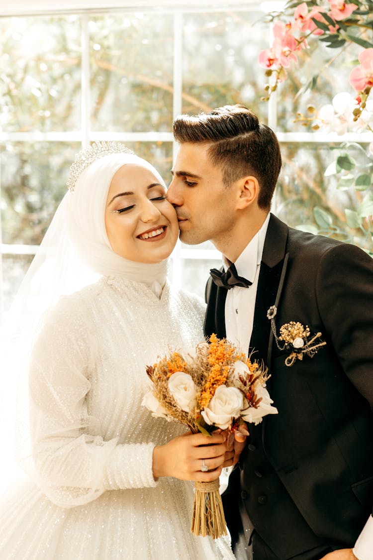 Man In Black Suit Kissing Woman In White Wedding Dress