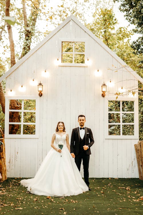 Man and Woman in Wedding Dress and Suit by House