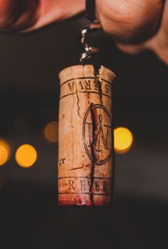 Detailed shot of a cracked, wine-stained cork on a corkscrew, evoking a rich, refined atmosphere.