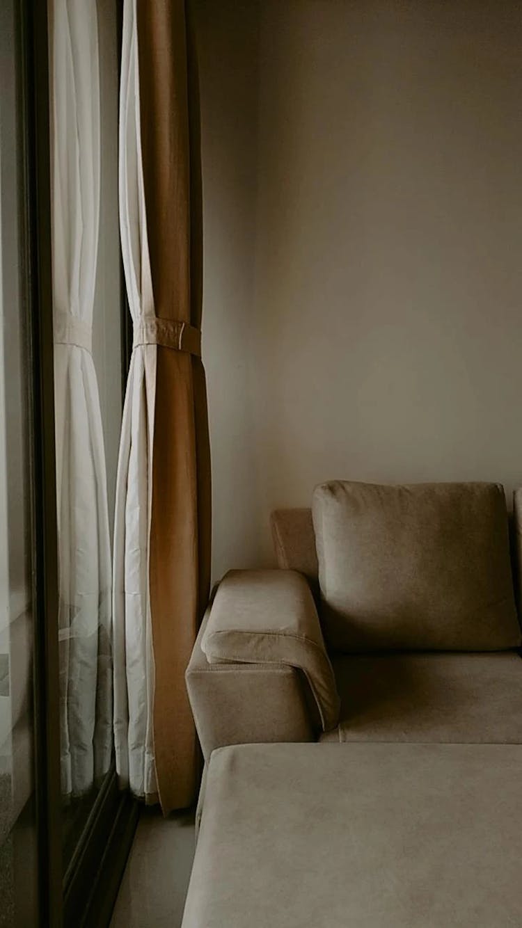 A Beige Sofa By A Window 