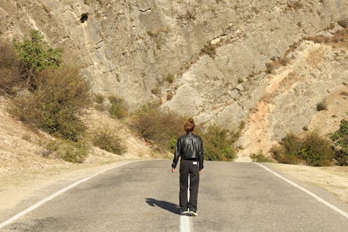 Woman in Black Jacket Standing on Road