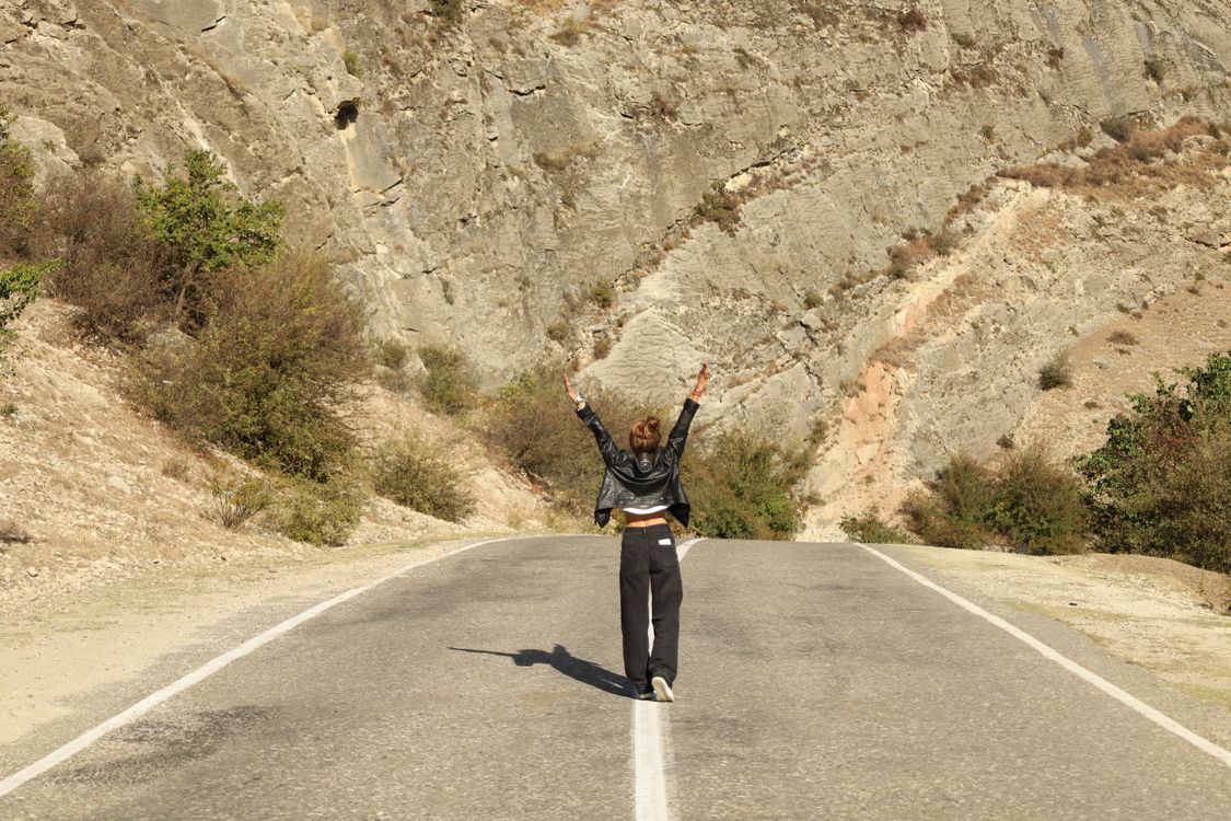 Woman in Black Jacket and Black Pants Standing on the Middle of Gray ...