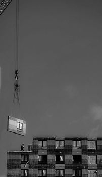 Aerial crane lifting prefab unit at Moscow construction site.