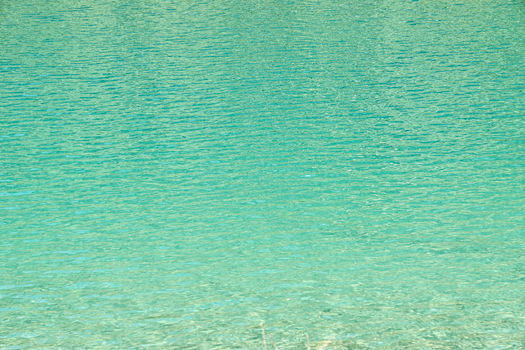 Calm turquoise ocean surface with gentle ripples creating a serene and refreshing atmosphere.