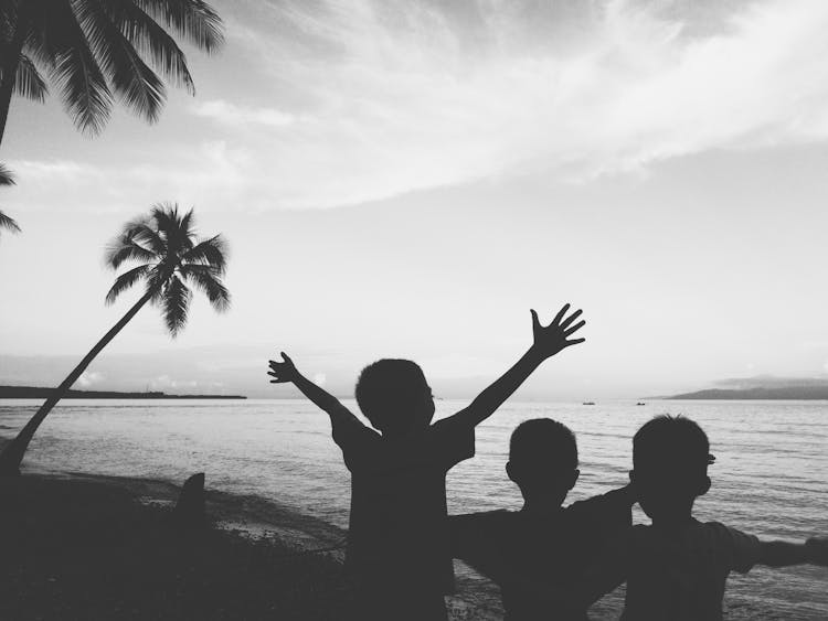 Children Standing On Beach Shore