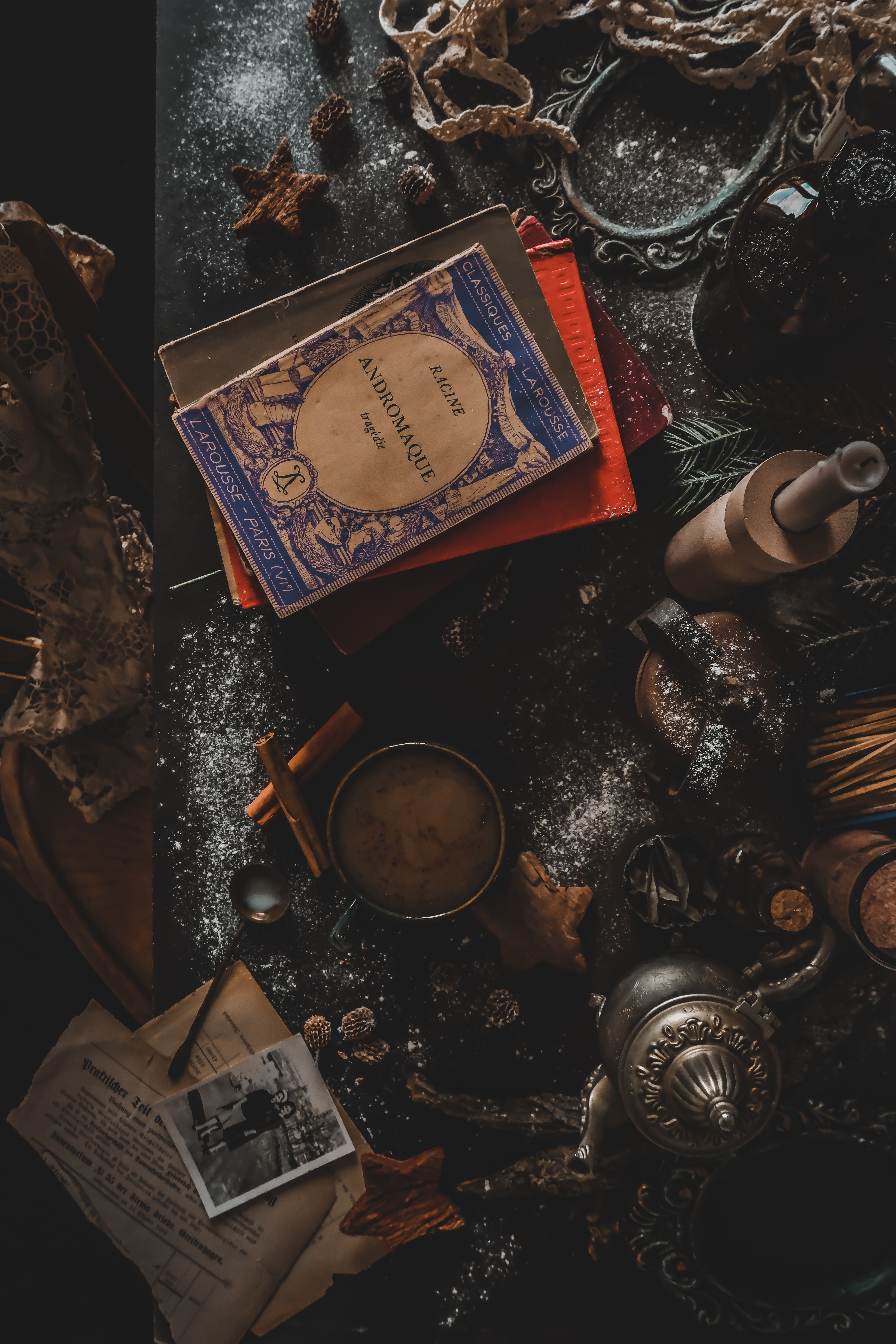 A cozy vintage setting featuring antique books and a traditional tea kettle.