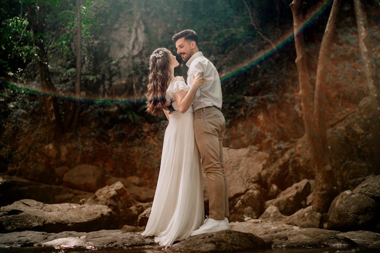 Wedding Photography Of A Romantic Couple Standing On The Rock