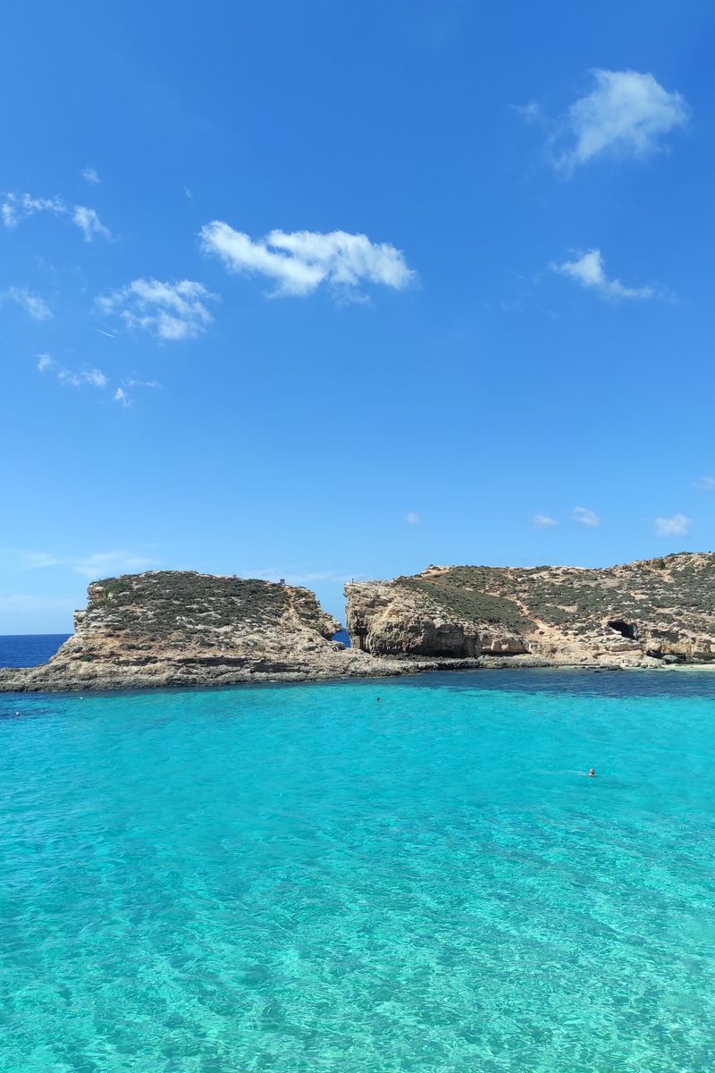 Stunning view of clear turquoise sea and rocky cliffs at Malta's Blue Lagoon, perfect for travel inspiration.