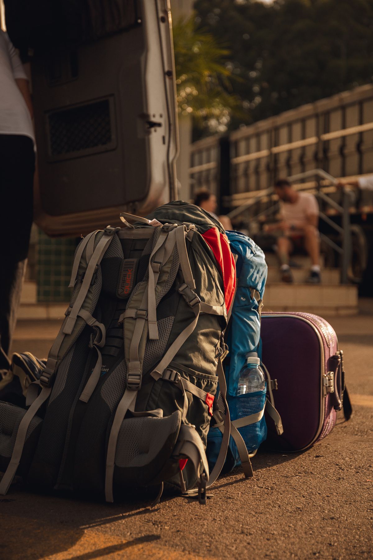 A loaded backpack and suitcases lined up on a station platform, showing how much luggage a group can travel with
