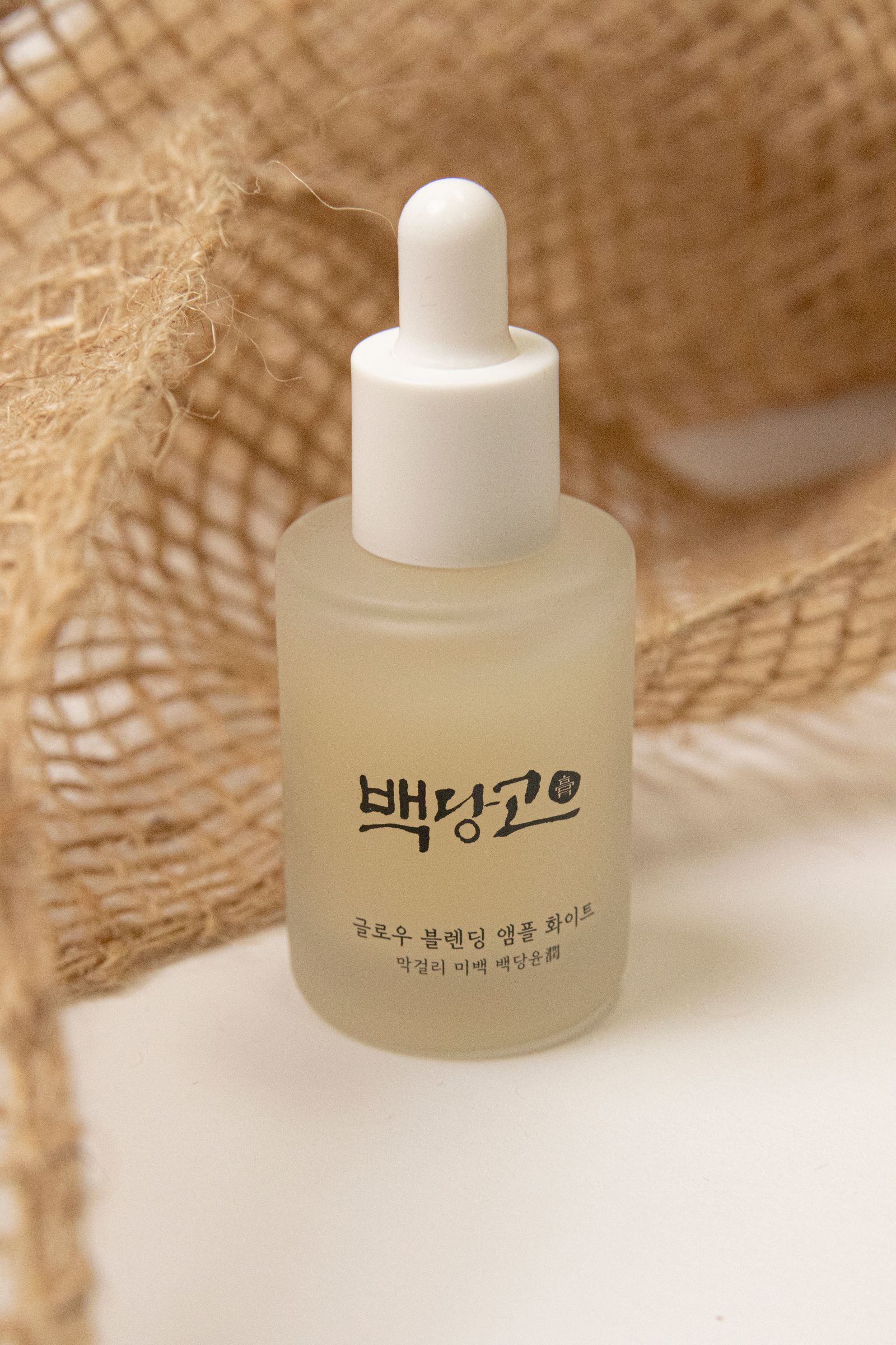 Skincare serum bottle photographed on white with soft shadow.