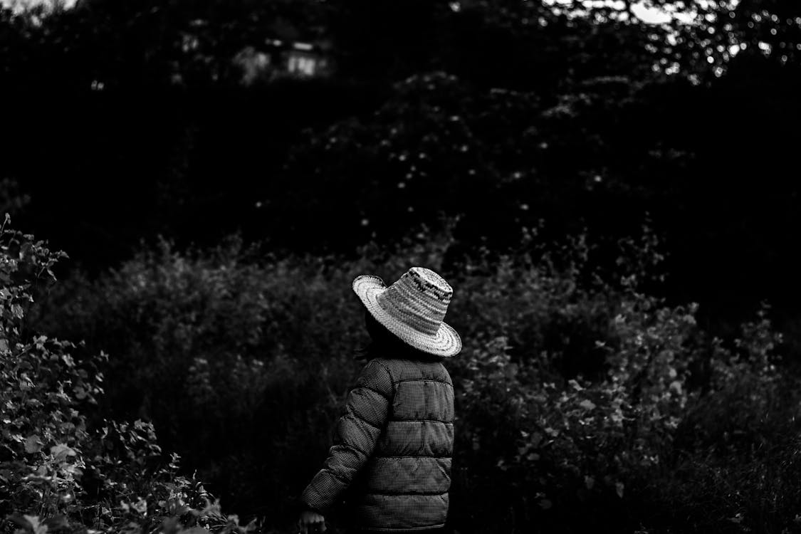 Grayscale Photo of Person Wearing Hat and Bubble Jacket